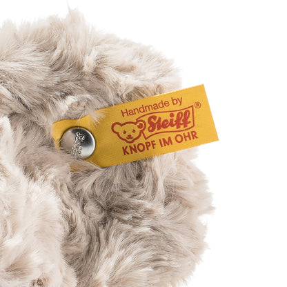 Close-up of a plush toy with a Steiff label on a white background