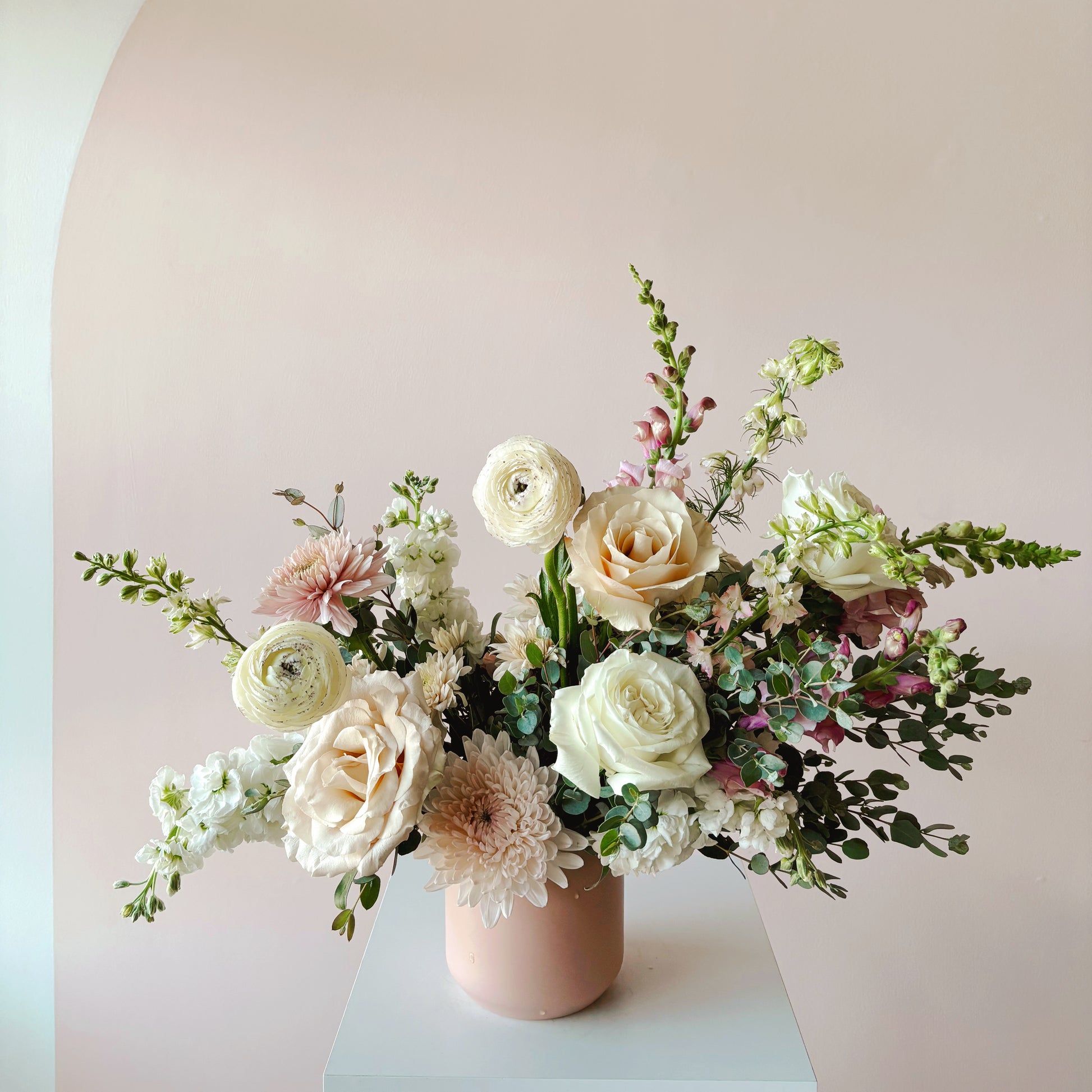 A mostly white flower arrangement in a pink vase. Dawn - Exclusive Luxury Flower Arrangement - Bloomstall Flowers & Plants - Columbia, Tennessee